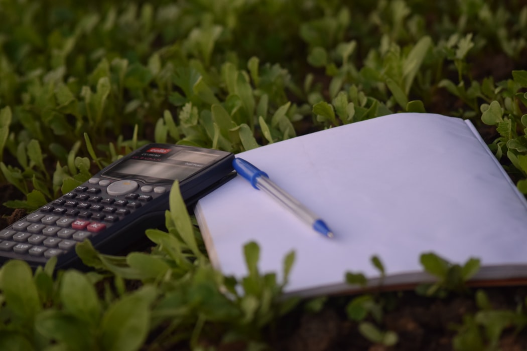 Calculator and notepad on lawn